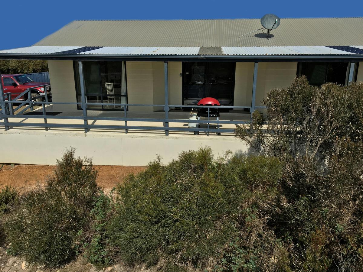 Island Time showing sheltered deck with BBQ, entrance to house and driveway for parking