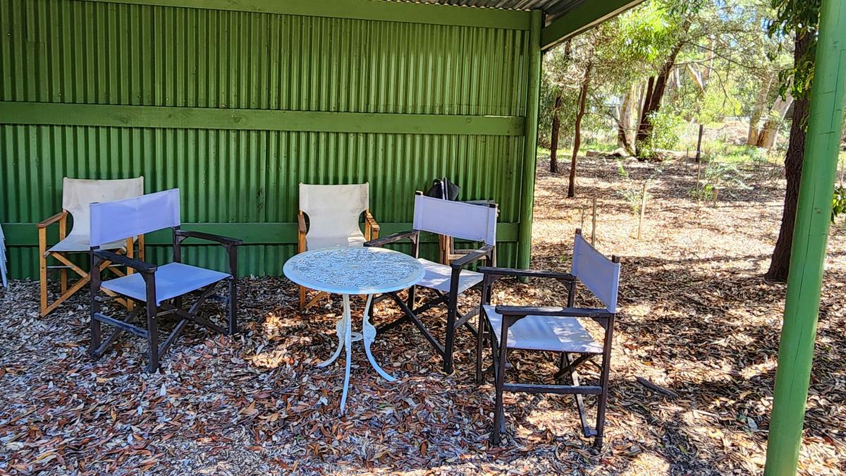 Tables and chairs in the sheltered, communal picnic area. Guests can sit back and watch wildlife in the Winter Wetlands. Summer, 2024. Kuitpo.