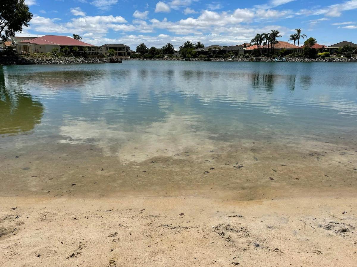 Swimming lake with sandy beach.