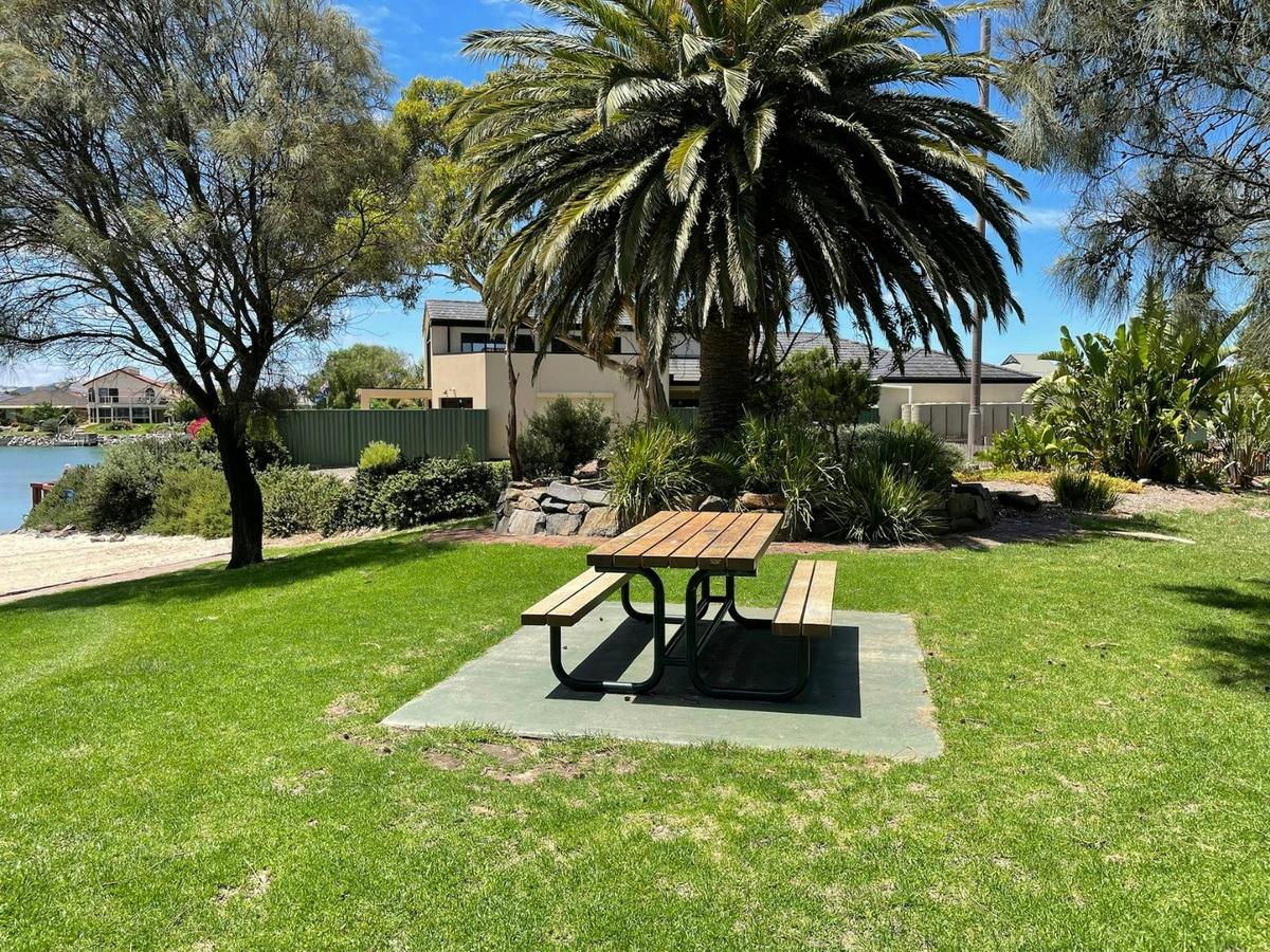 Picnic table on the grass with surrounding trees.