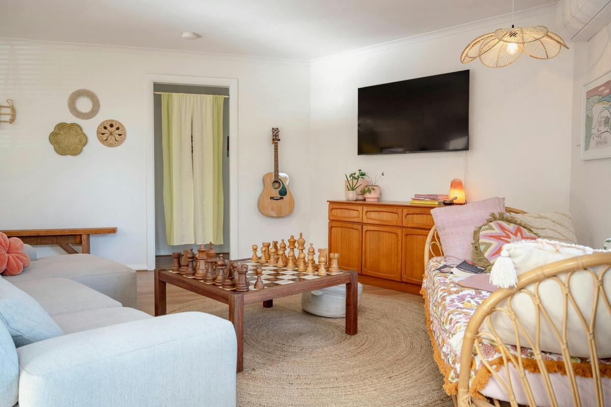 Living room - includes large 3 seater sofa, daybed, chess table, games cupboard, and TV