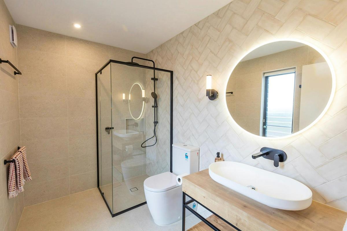 Bathroom including shower, sink, mirror and toilet