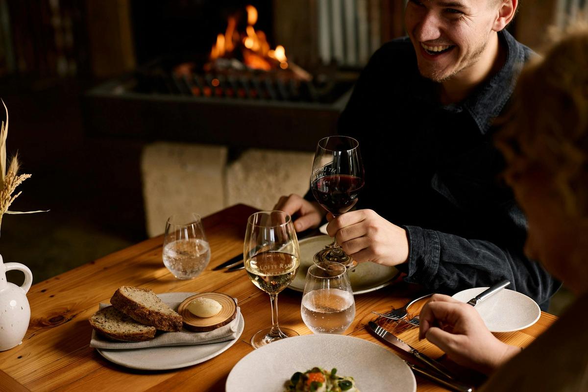 Table set with food and wine. Fire in the background.