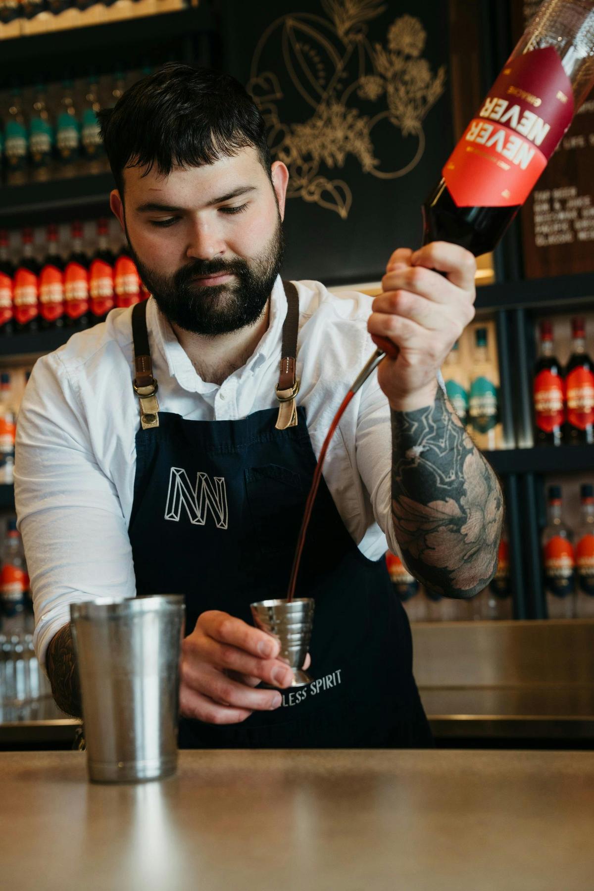 bartender pouring never never ginache into measuring cup