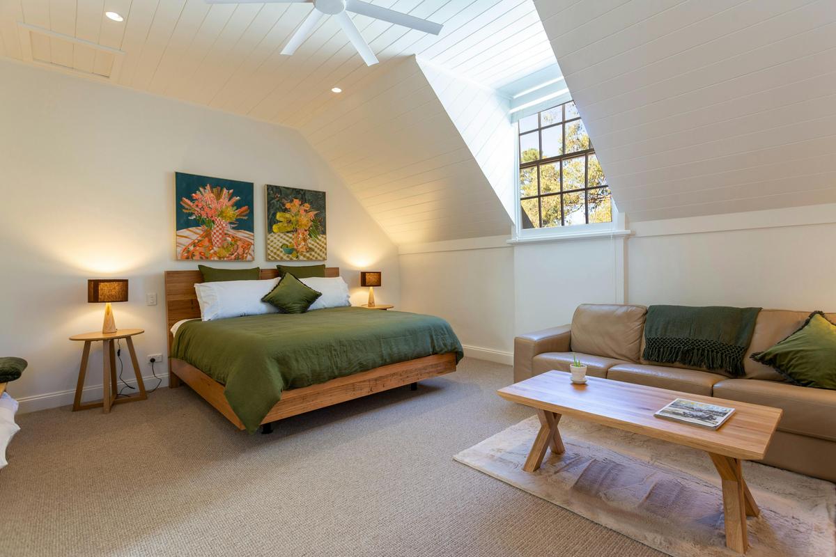The spacious bedroom with a king-sized bed and sofa