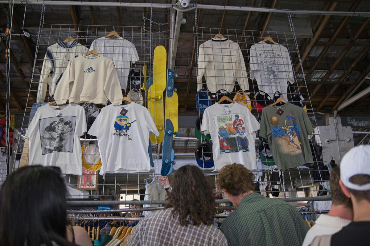 Eyes up—rare 90s graphic tees and jackets hang high in the warehouse’s vault