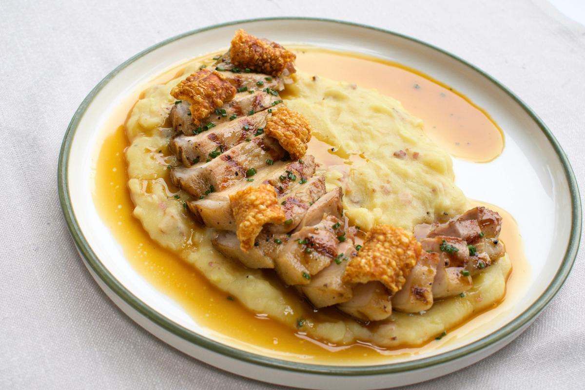 a photo of pork loin on a bed of creamy mashed potato