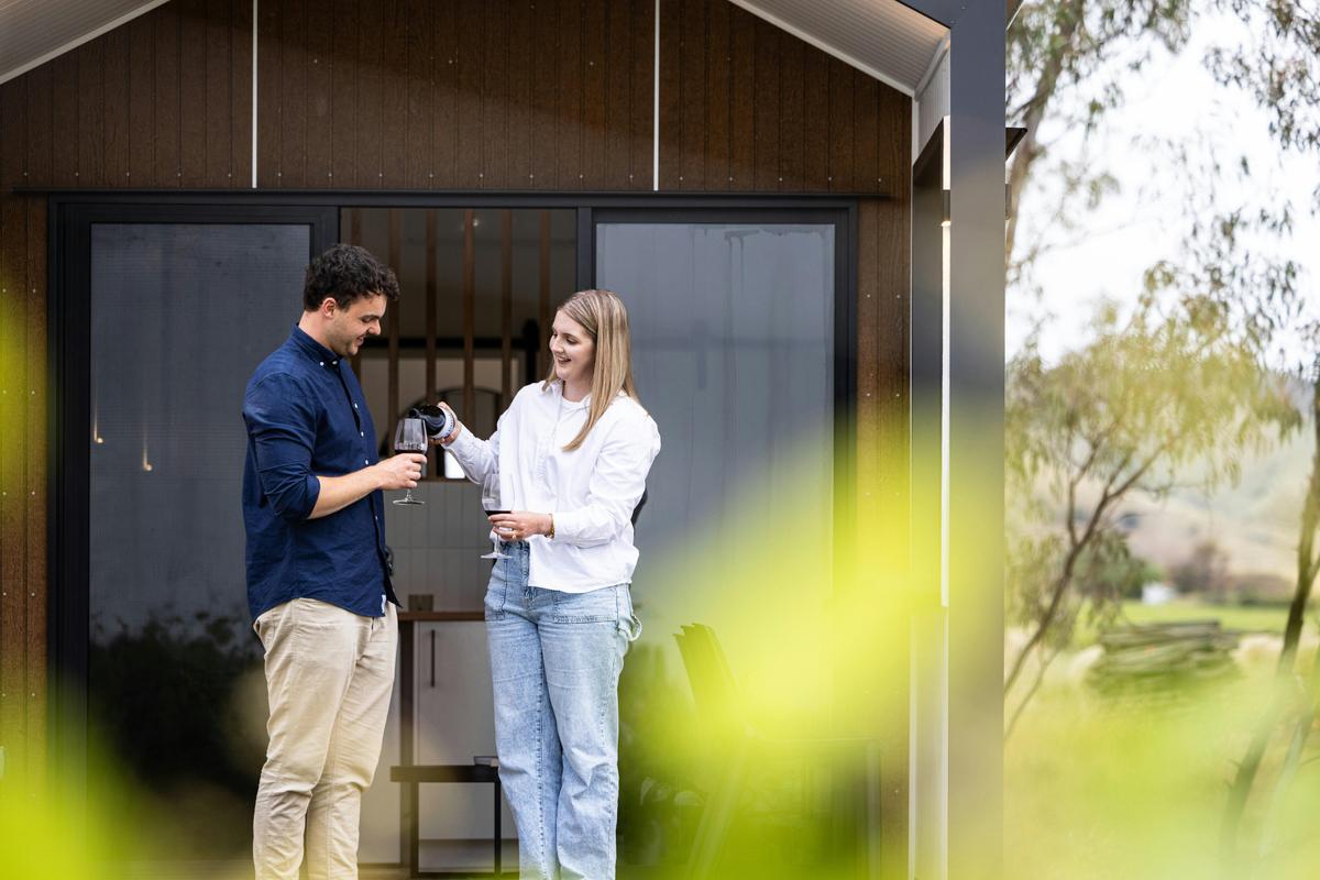 Couple on deck of cabin with wine