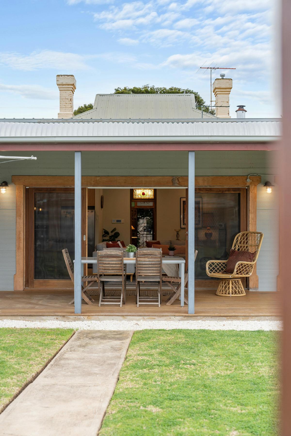 Charming outdoor patio with a dining table and wooden chairs, perfect for summer evenings..