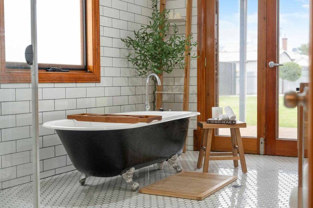Indulge in a relaxing soak in a stunning clawfoot bathtub with garden views