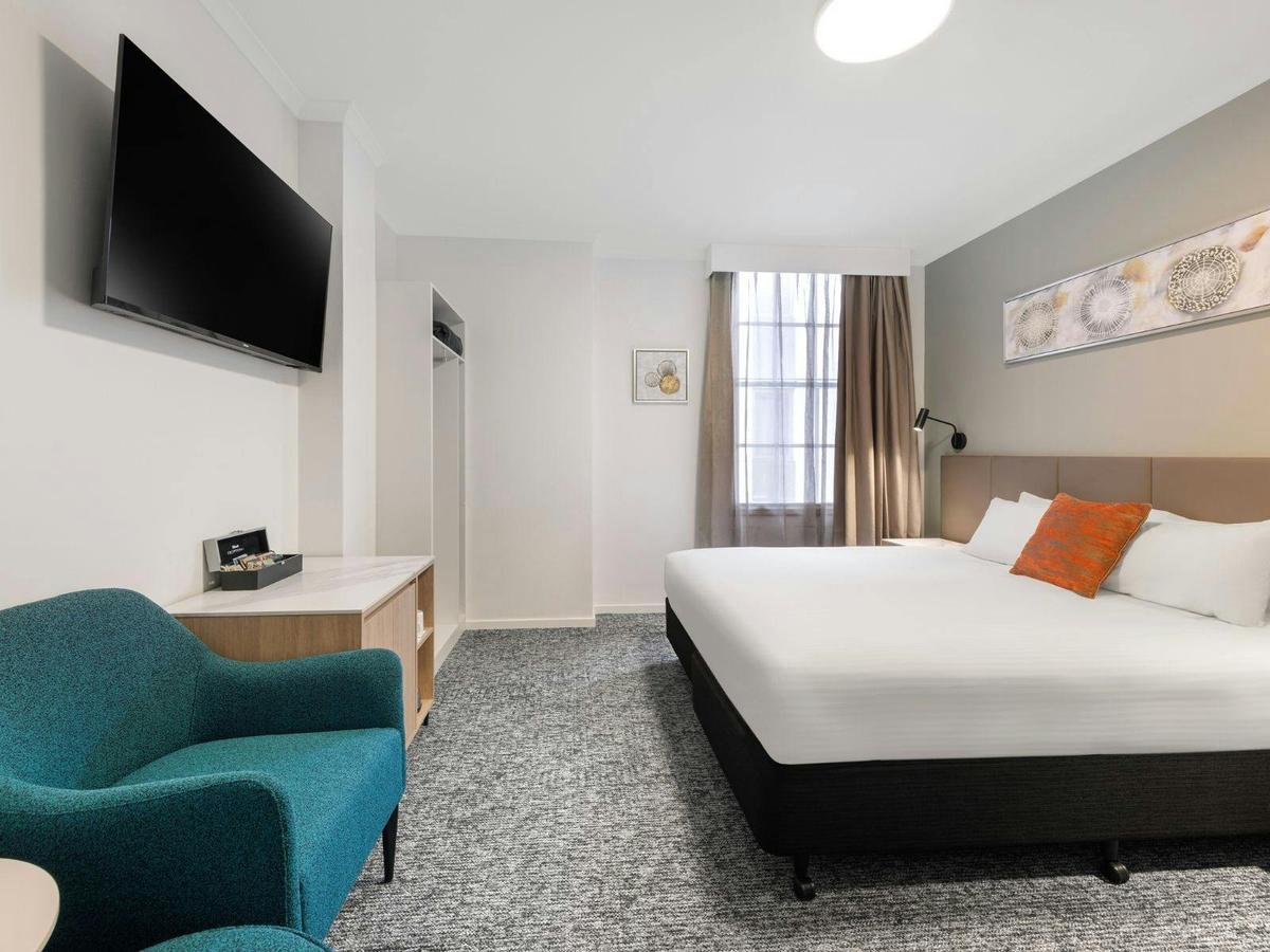 Spacious King Room featuring a plush bed, modern furnishings, and a cozy ambiance in Adelaide.