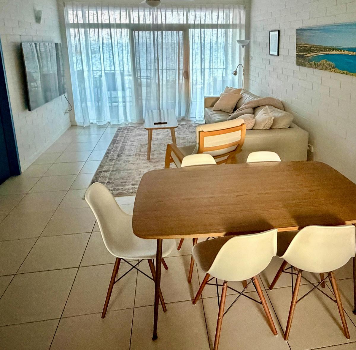 Dining area with wooden table and chairs overlooking the balcony