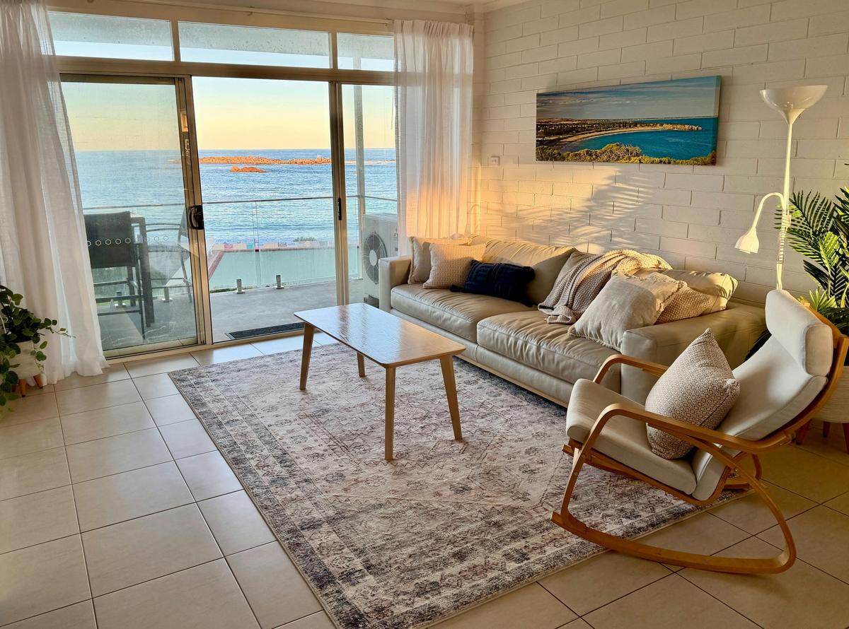 Bright living room with sofa, coffee table and ocean views