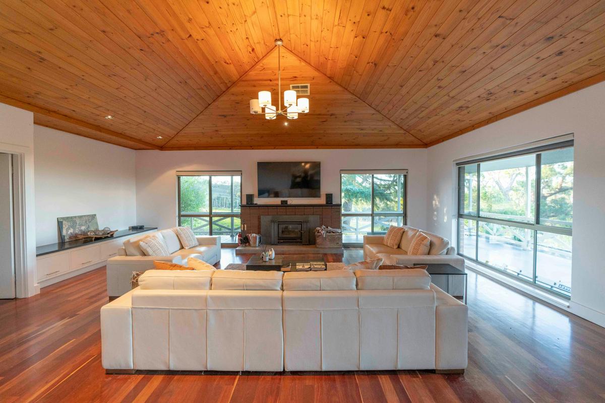 Large lounge room with three couches and a fireplace