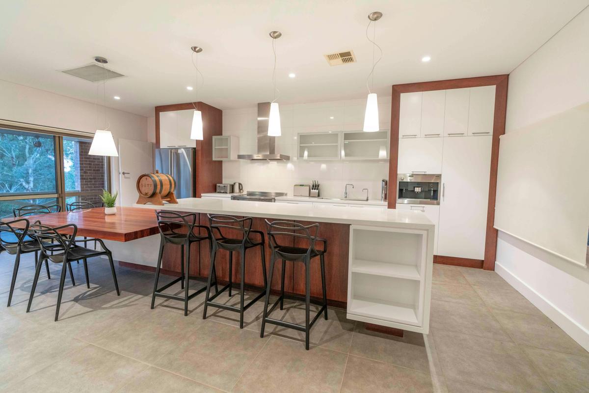 Kitchen area featuring kitchen benches and chairs, seats 7