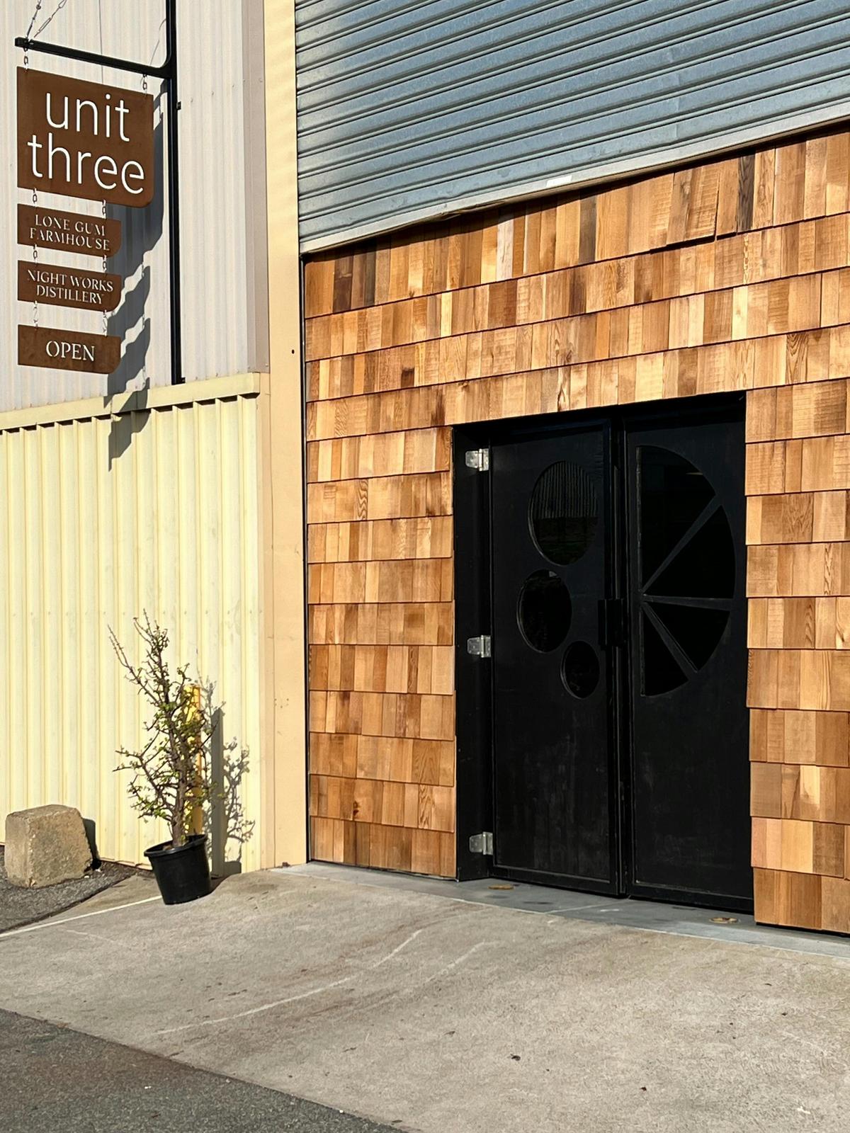 wooden doorway welcoming you to a hidden bar in an industrial shed