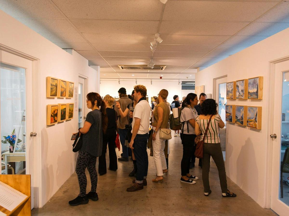 A group of people look at artwork on the walls of The Mill's galleries