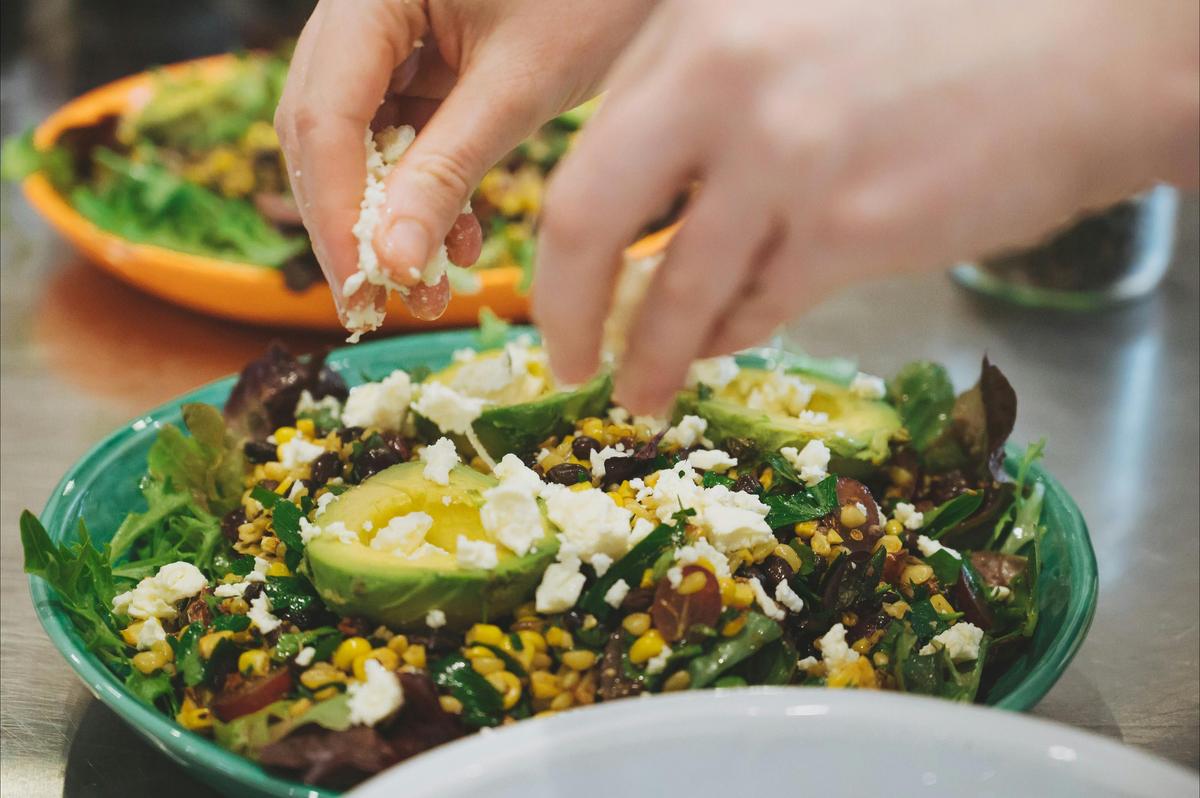 Assembling a delicious salad at a Green Gourmet cooking workshop