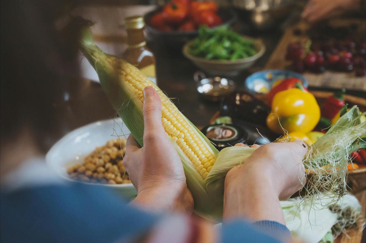 A cooking workshop participant preparing corn