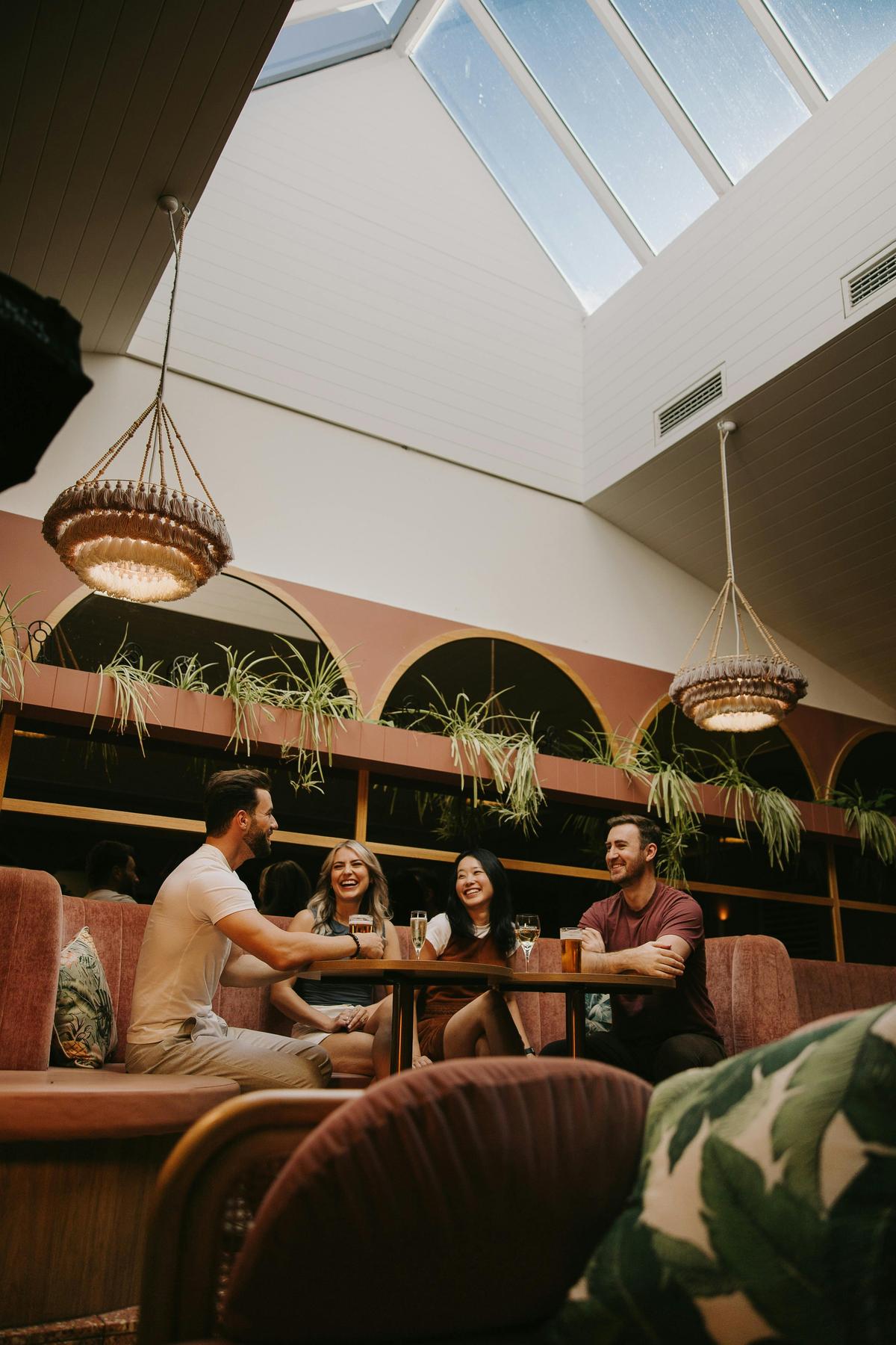 Friends eating at a booth under the skylight
