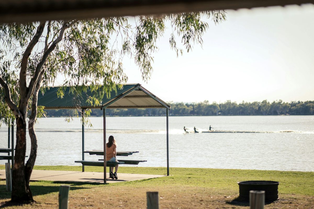 Woman sitting in picnic area watching lake