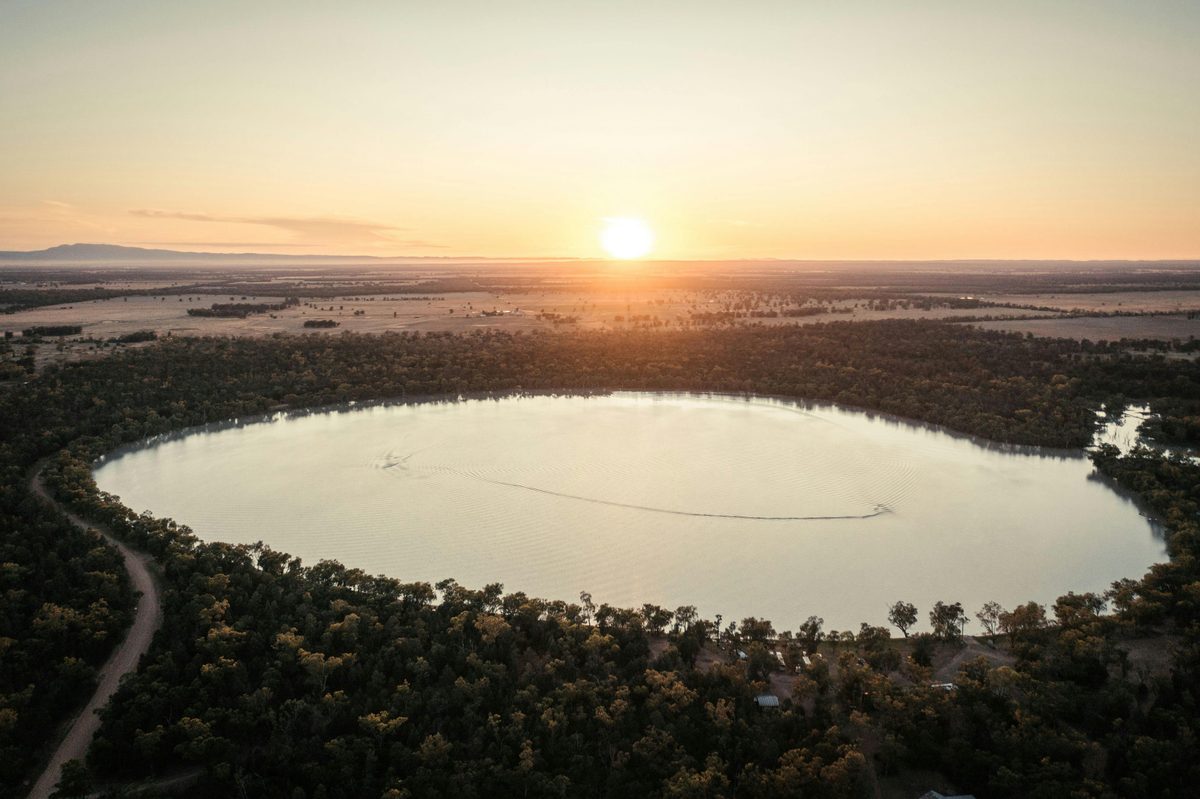 Aerial photo of lake at sunset with mountains in the distance