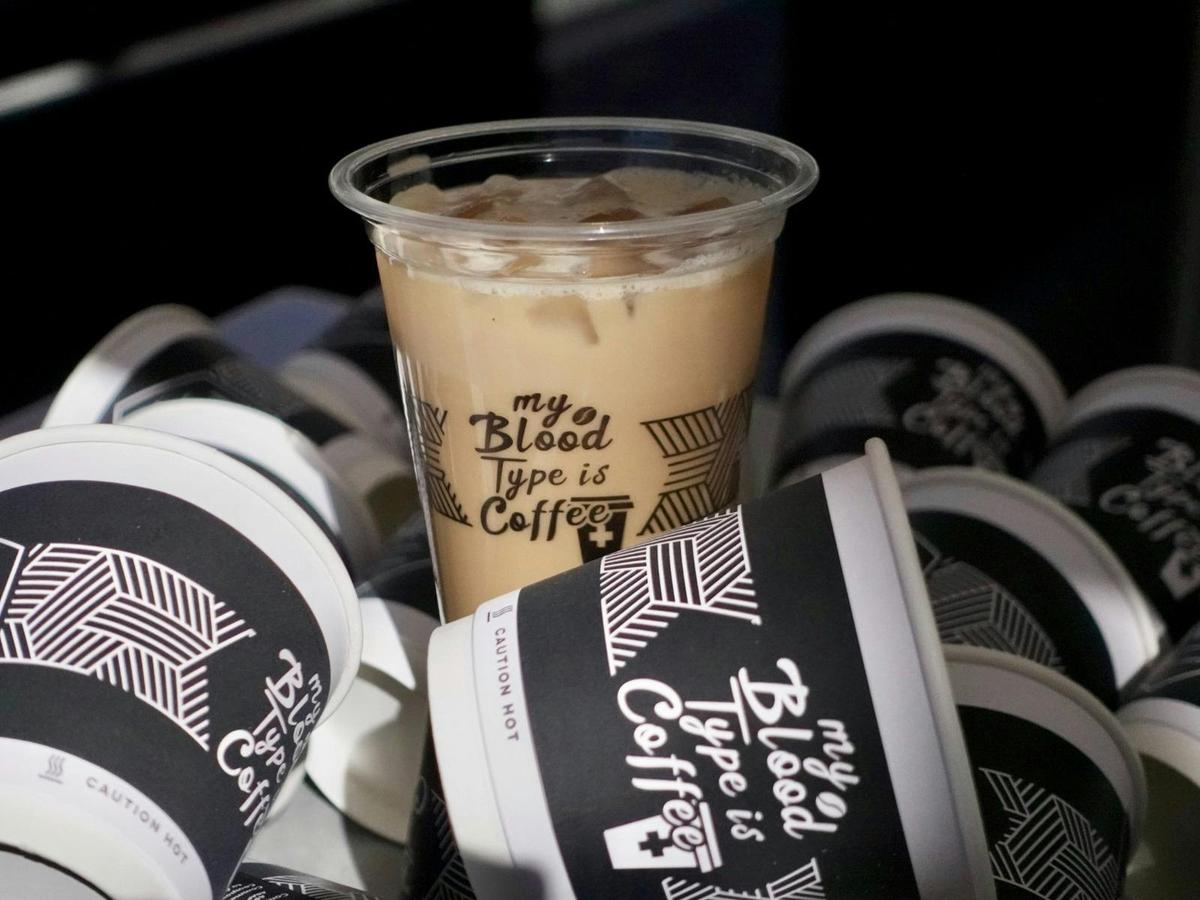 Kafin iced coffee surrounded by our signature branded takeaway cups