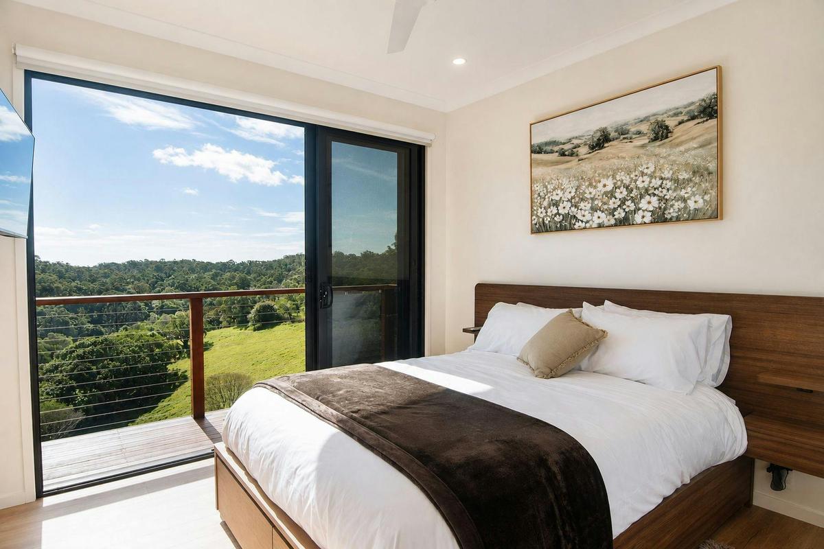 peaceful queen bedroom with natural light and views across the surrounding bushland.