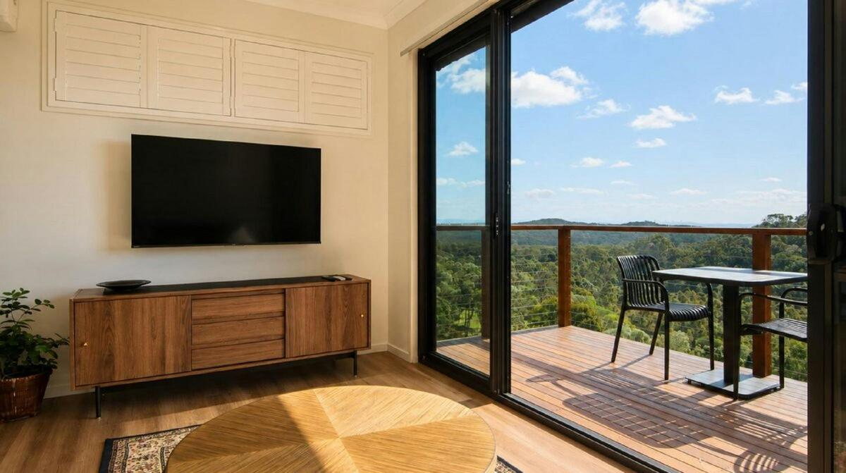 A comfortable, light-filled living room opening directly onto the private deck and bushland views.