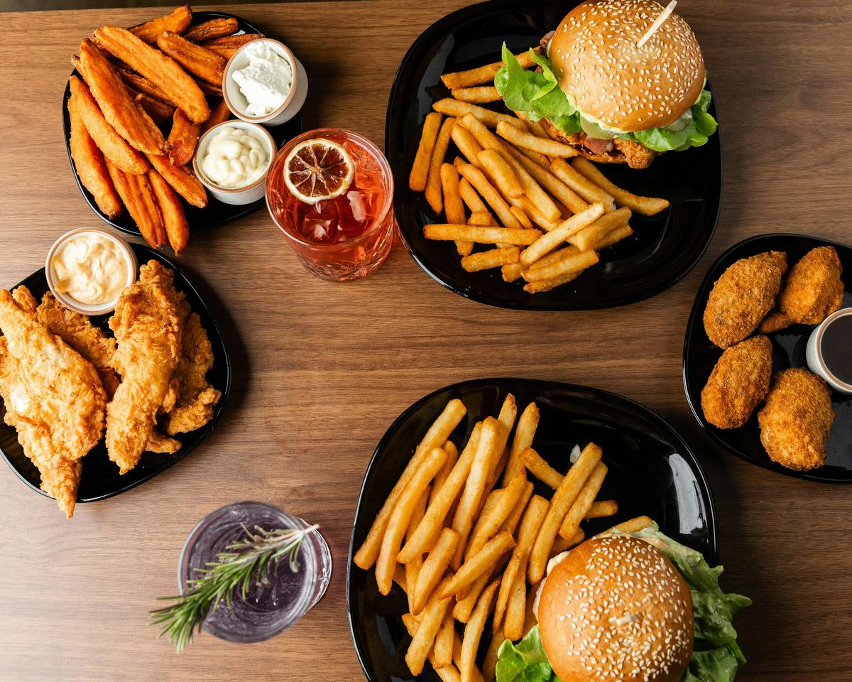 A shared table spread of burgers, fries, and sides.