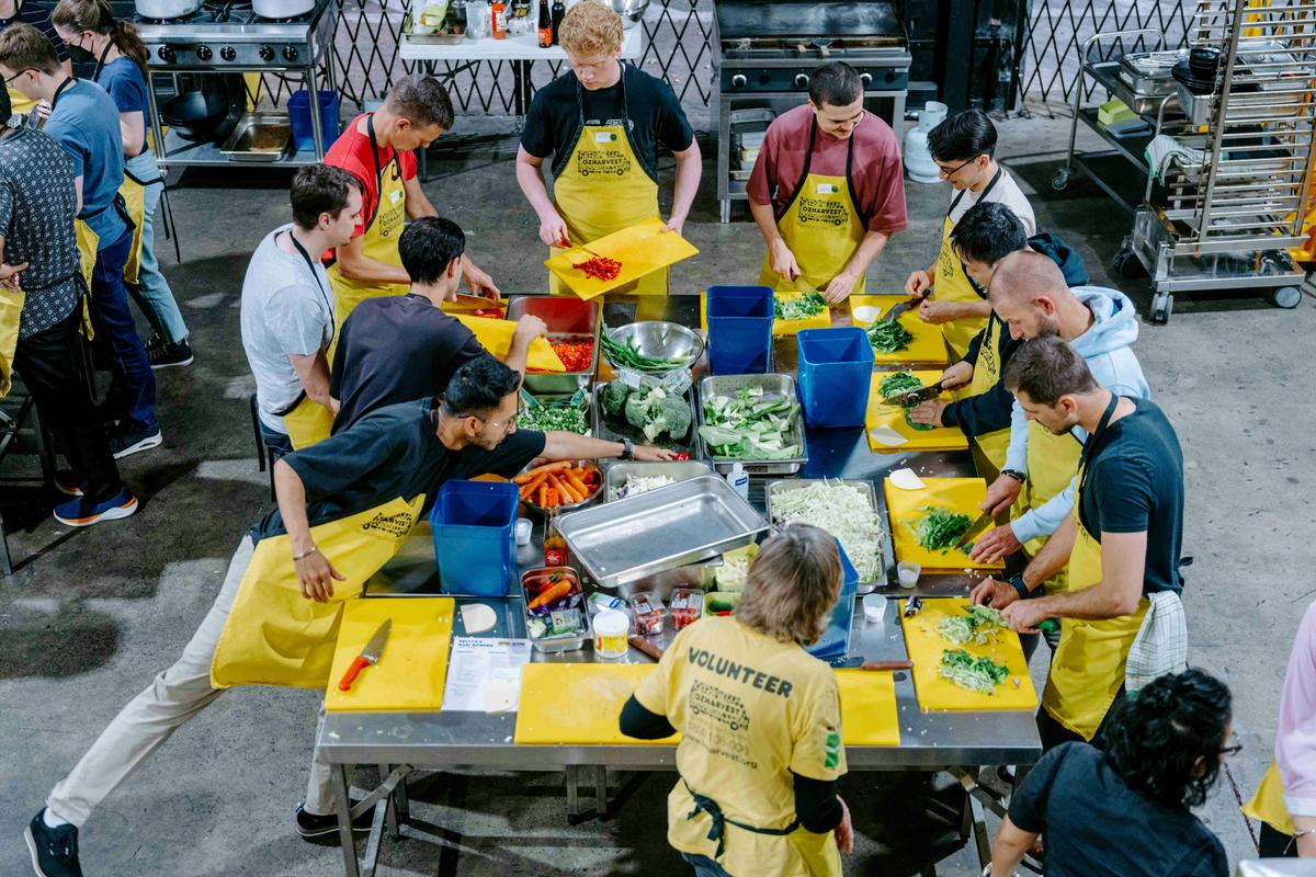 All hands on deck, a big group chopping veggies together.