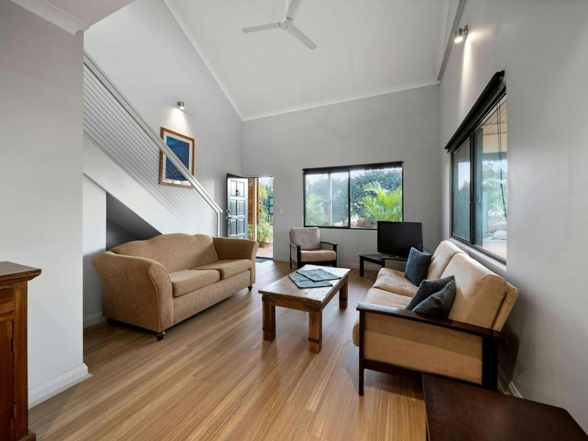Bright lounge with high ceilings, comfortable seating, and garden views.