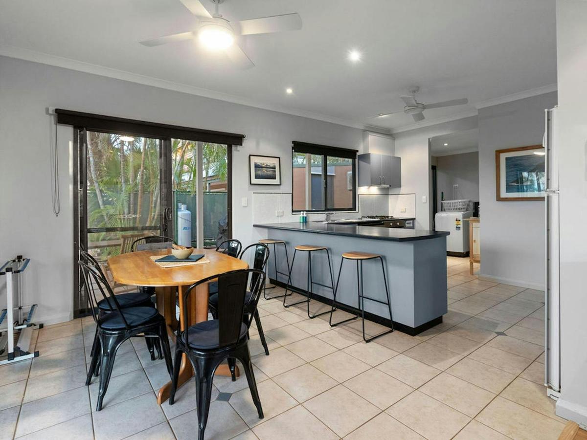 Open dining and kitchen area with breakfast seating and outdoor access