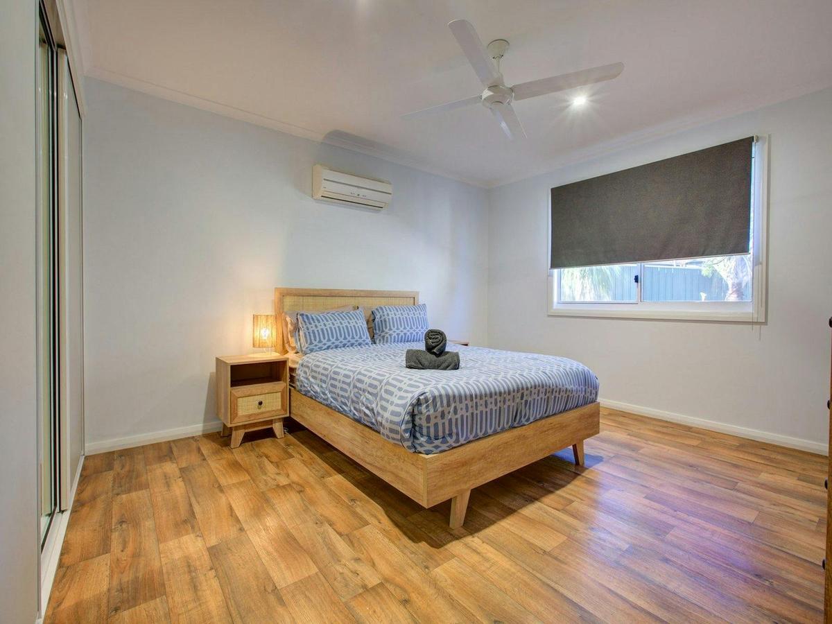 Light-filled master retreat with air conditioning, ceiling fan and coastal décor.