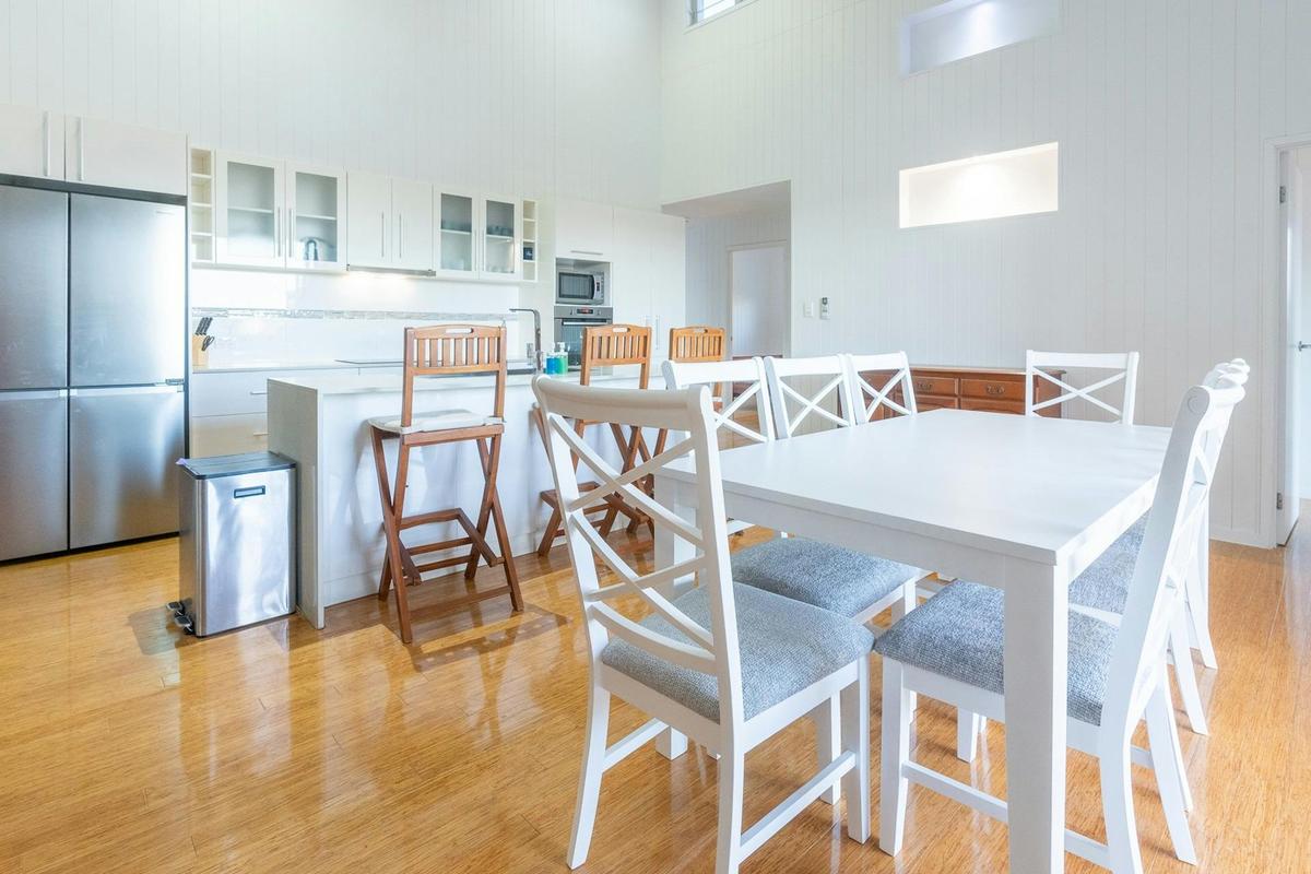 Light-filled kitchen and dining area with breakfast bar seating.