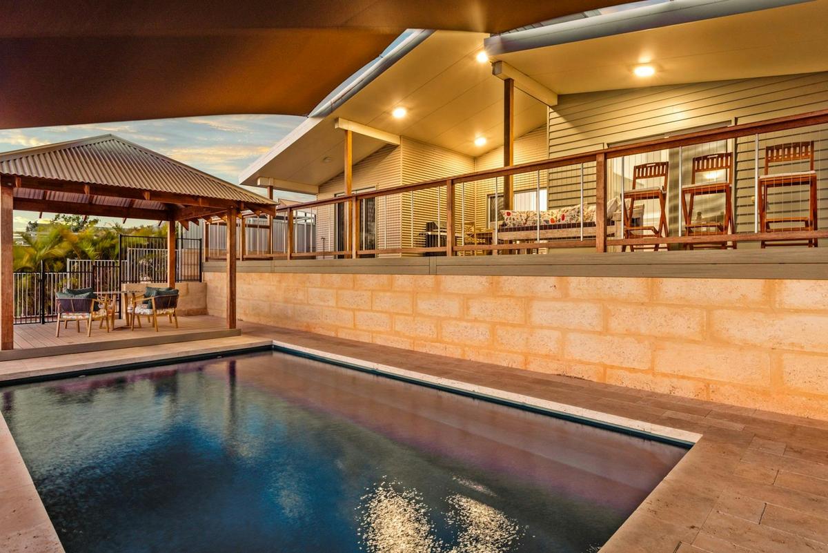 Pool and covered outdoor entertaining areas at dusk.