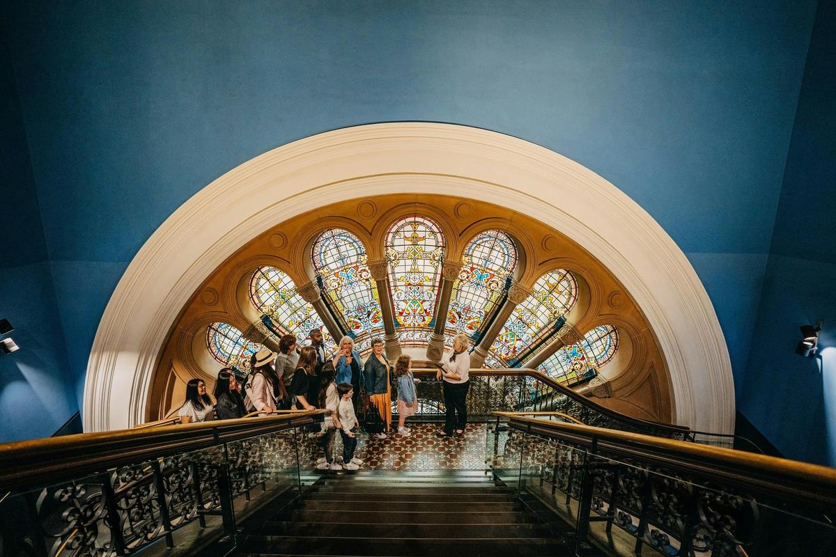 A QVB History Tour group stopping at one of the stained glass windows