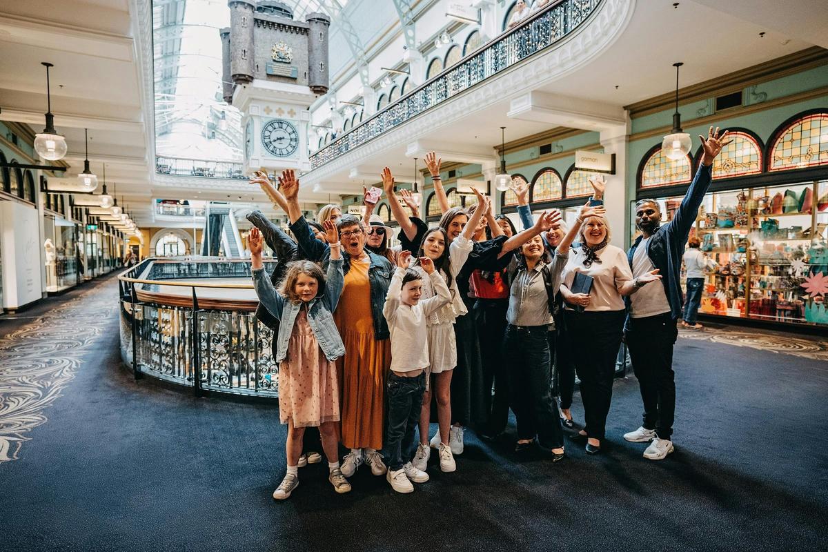 A tour group taking a photo on level one of the QVB