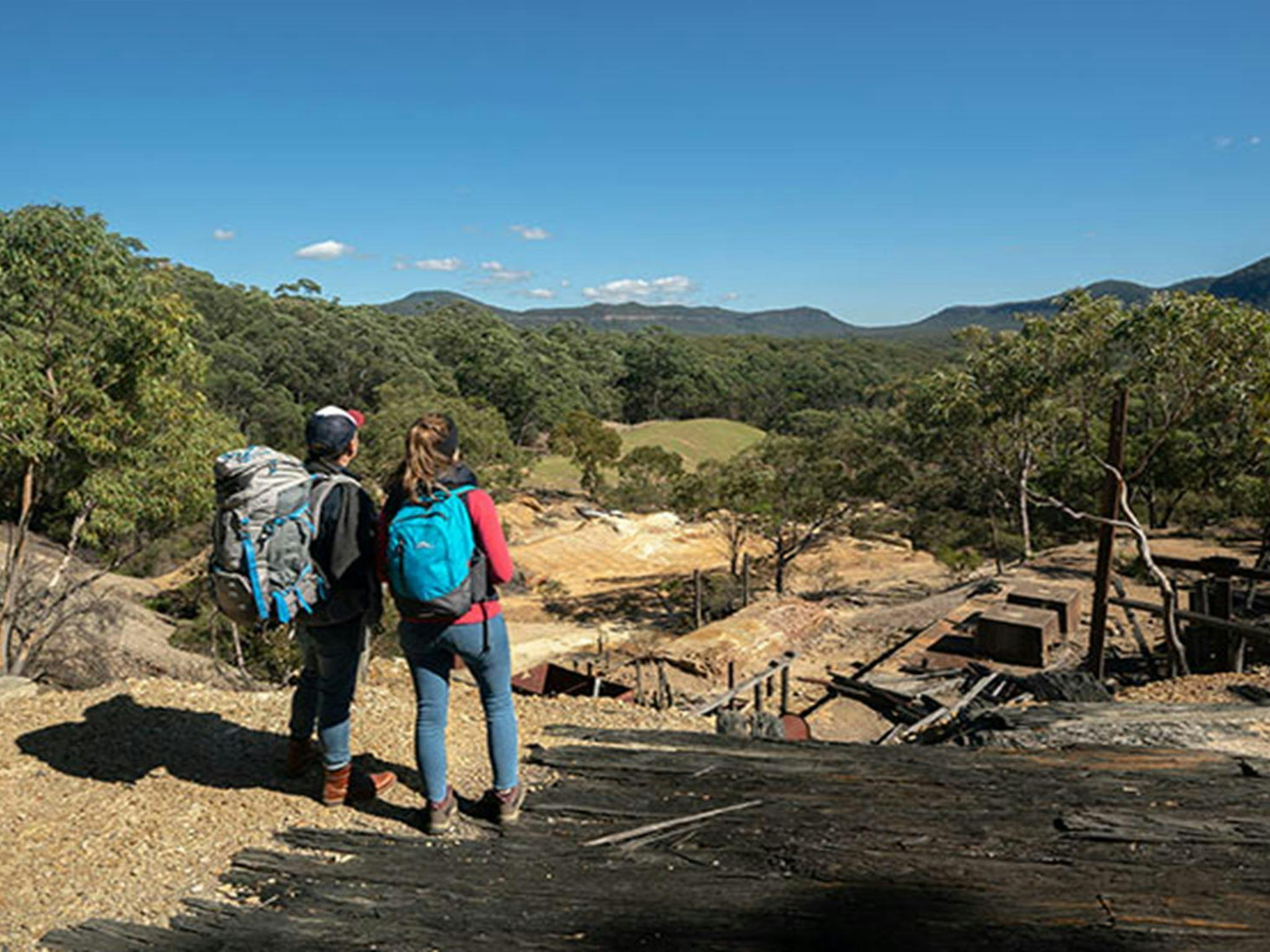 A couple looking across the remnants of historic Silver Peak Mine to Yerranderie Regional Park.