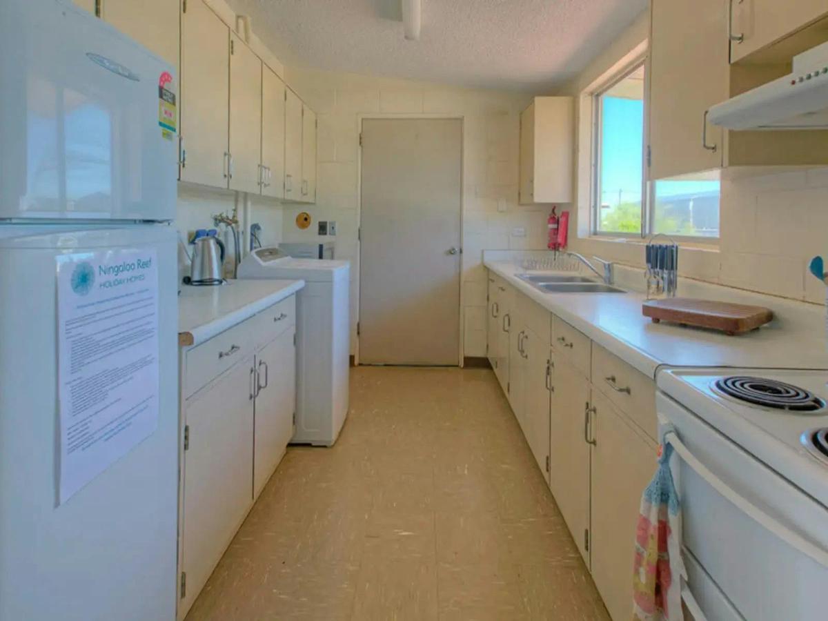 Full kitchen with ample cabinet space, appliances, and a washing machine