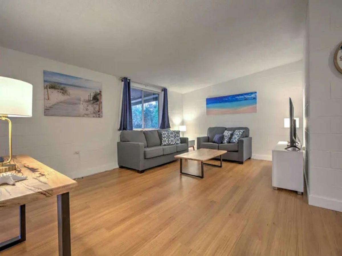 Bright open living room with comfortable seating and warm timber floors