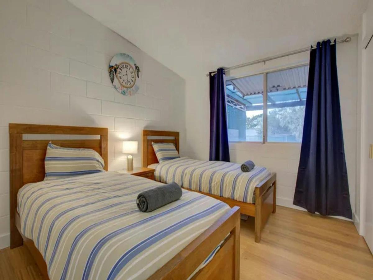 Comfortable twin bedroom with timber beds and fresh coastal styling