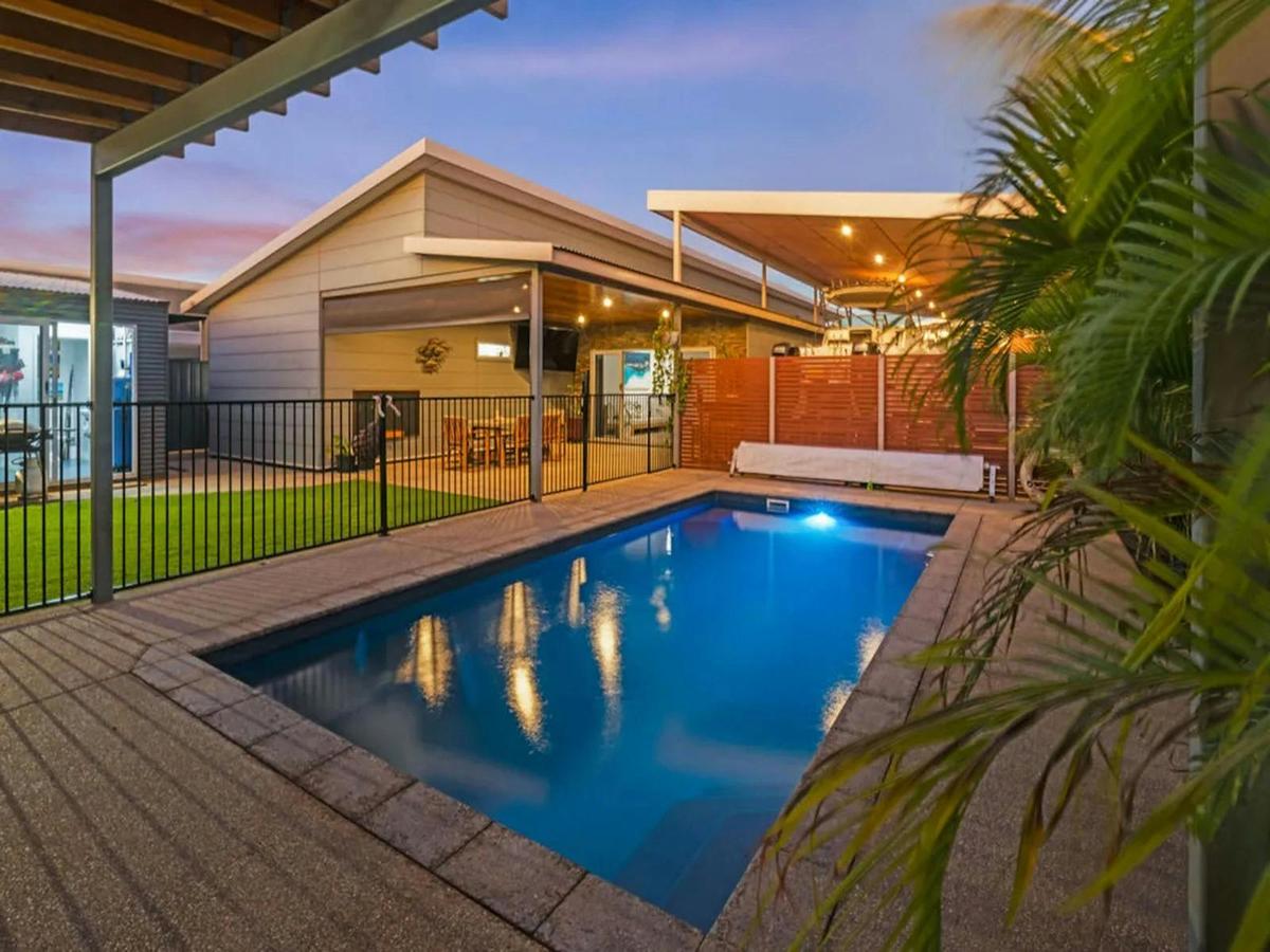 Private pool surrounded by tropical greenery and covered outdoor living