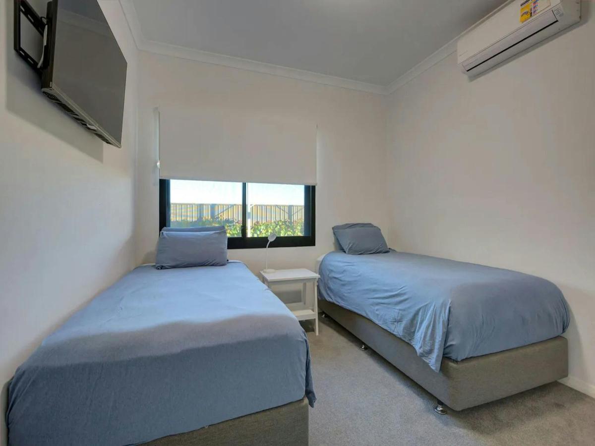 Bright twin bedroom with air conditioning, a television and garden views