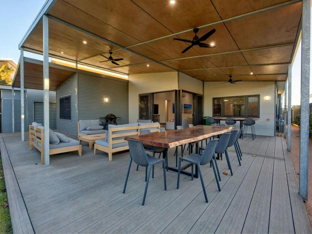 Spacious covered patio with outdoor dining, lounge seating and ceiling fans