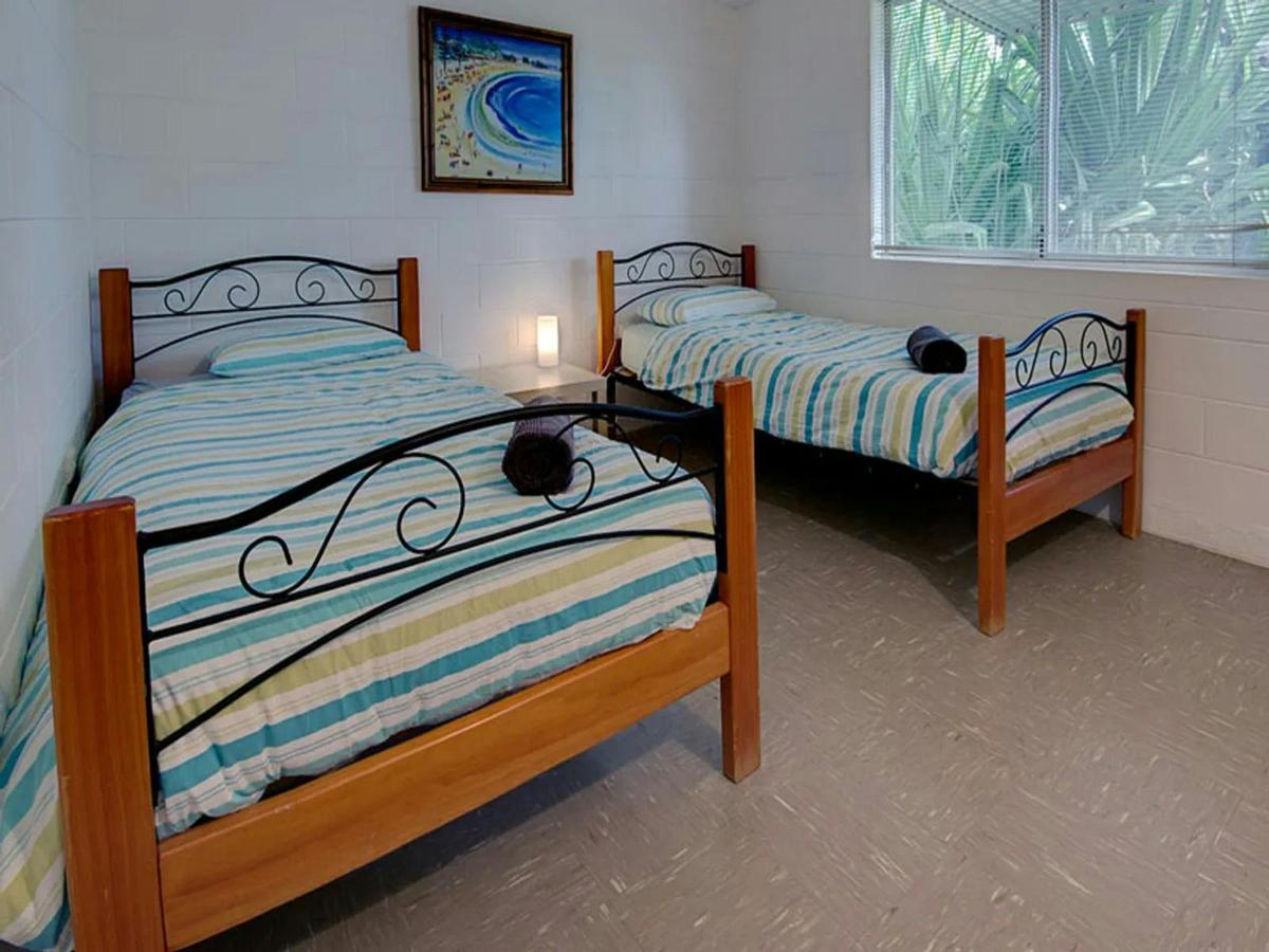 Family bedroom with three single beds and leafy garden views