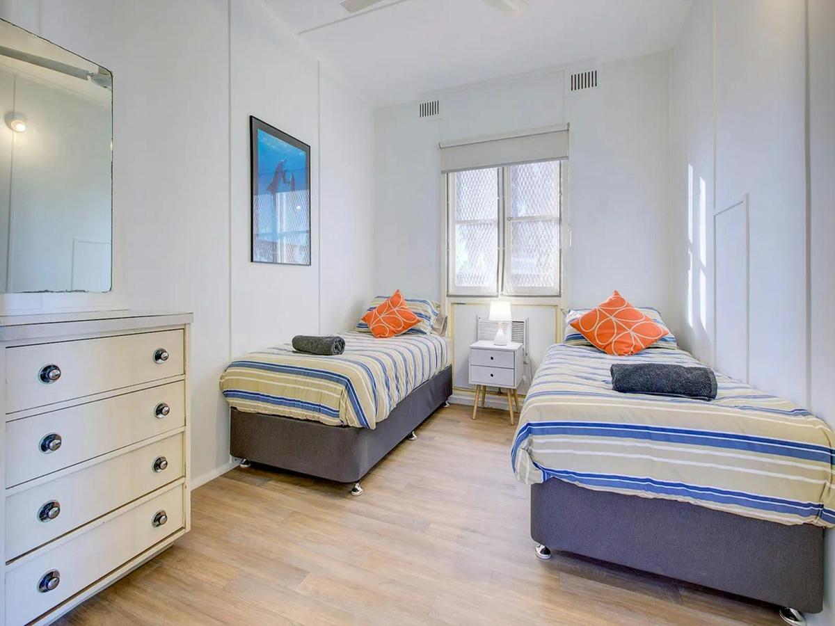 Bright twin bedroom with colourful accents and generous natural light