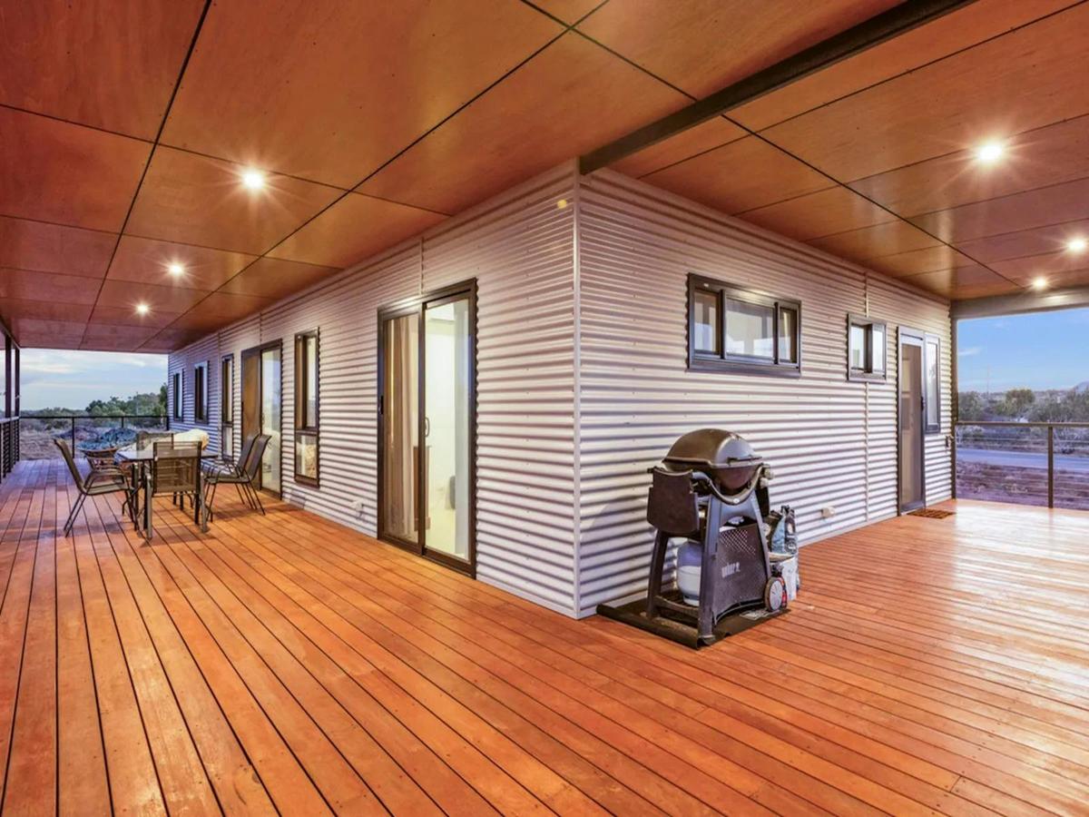 Expansive covered deck with outdoor dining, seating and a barbecue