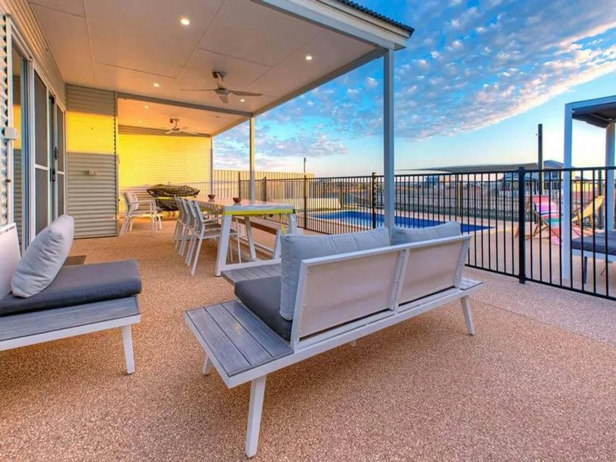 Covered poolside patio with outdoor dining and comfortable lounge seating