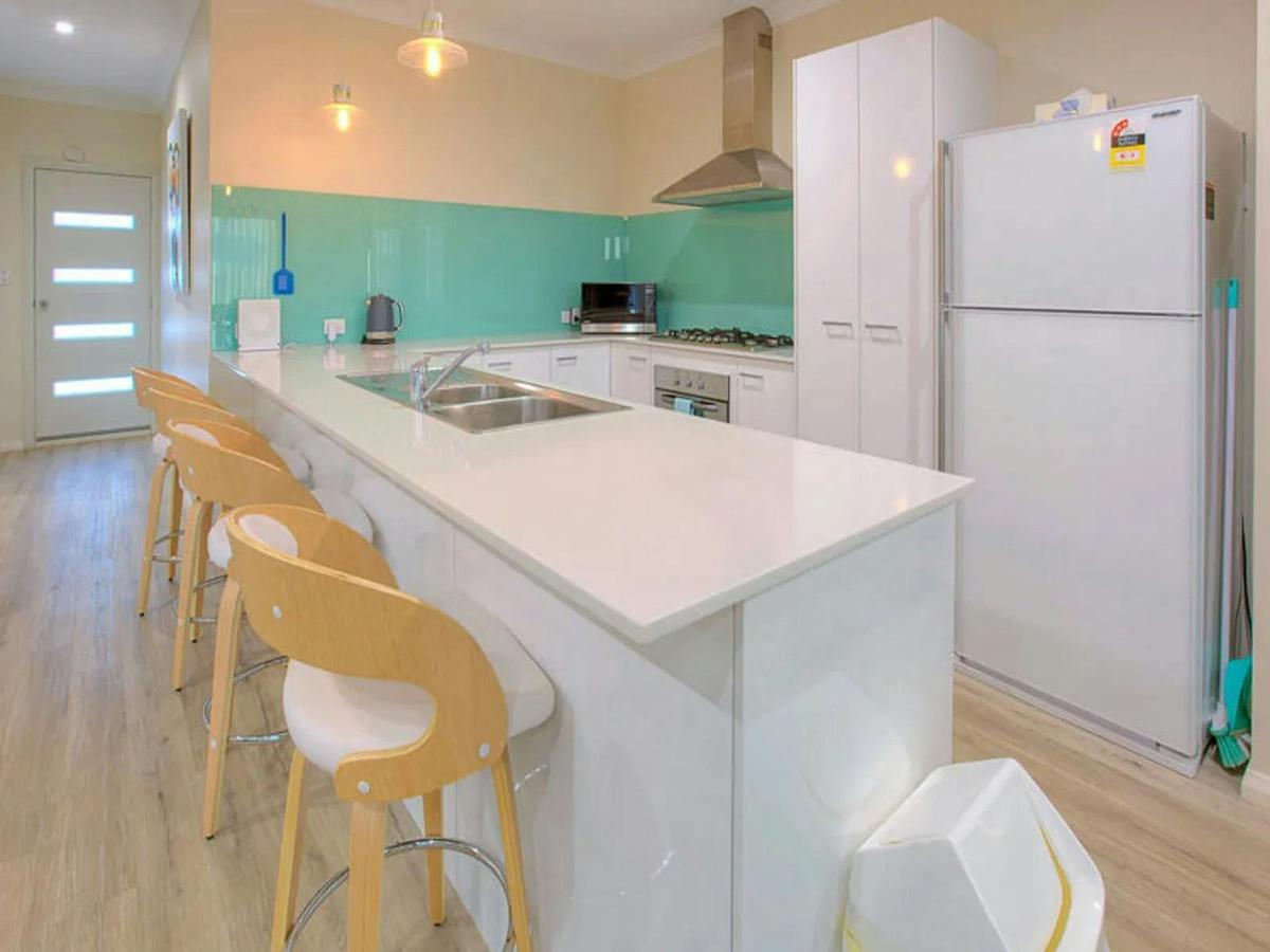 Modern kitchen with a breakfast bar, ample storage and turquoise accents